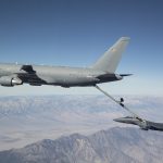 aerial tanker refueling a fighter jet above the mountains