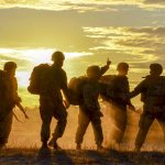 army soldiers in front of a sunset