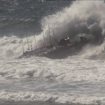 An amphibious vehicle crashes into a wave in high ocean surf
