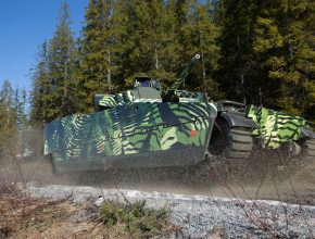 tracked combat vehicle driving offroad near a forrest