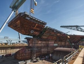 a ship being built in dry dock using a crane