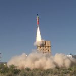 missile launch with visible exhaust creates a cloud of dust