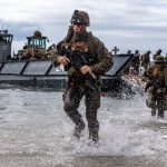 Marines runn out of an amphibious landing craft