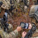 soldiers look at a tablet during training