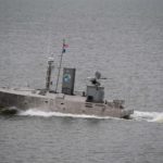 small unmanned vessel outfitted with electronics and weaponsmoves through the water