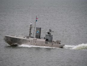 small unmanned vessel outfitted with electronics and weaponsmoves through the water