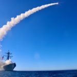 a missile leaves a trail of smoke after being launched from a ship in the ocean
