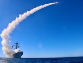 a missile leaves a trail of smoke after being launched from a ship in the ocean