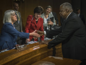 A U.S. senator shakes hands with the secretary of defense at a congressional hearing