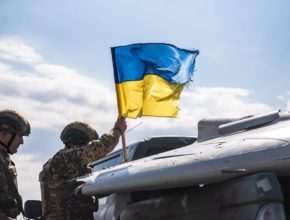 soldiers plant a Ukrainian flag on a truck