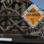 a warning sign mounted on a pallet of munitions