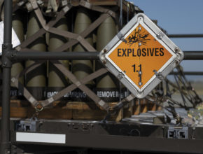 a warning sign mounted on a pallet of munitions