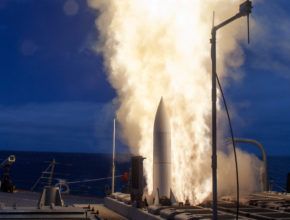 Exhaust flames shoot out alongside a missile being launched from a ship