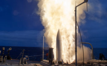 Exhaust flames shoot out alongside a missile being launched from a ship