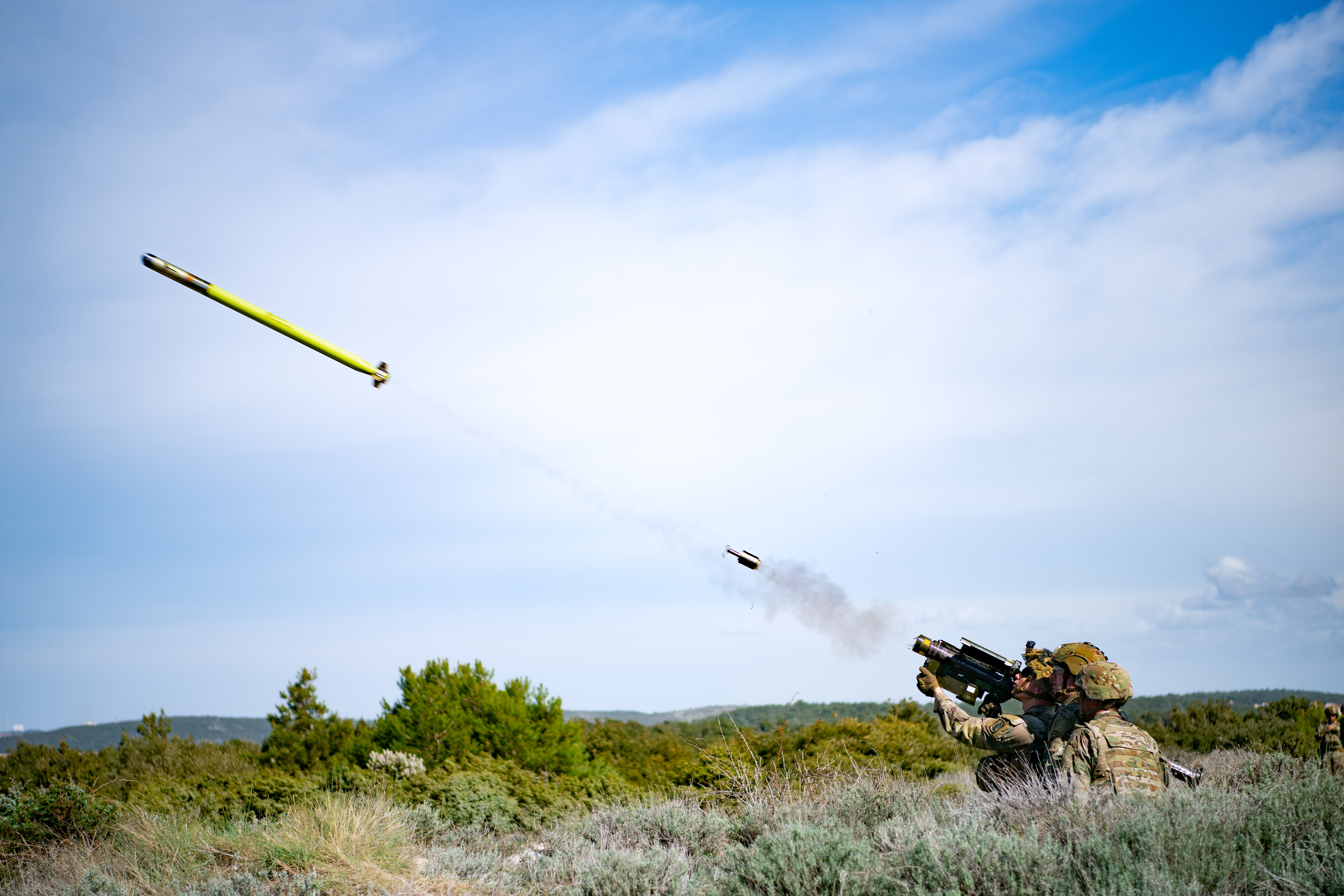a soldier fires a missile into the air from a handheld launcher