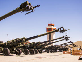 howitzers lined up near an air traffic control tower