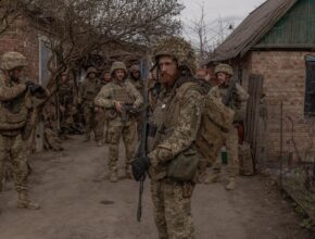 armed soldiers gather in a village