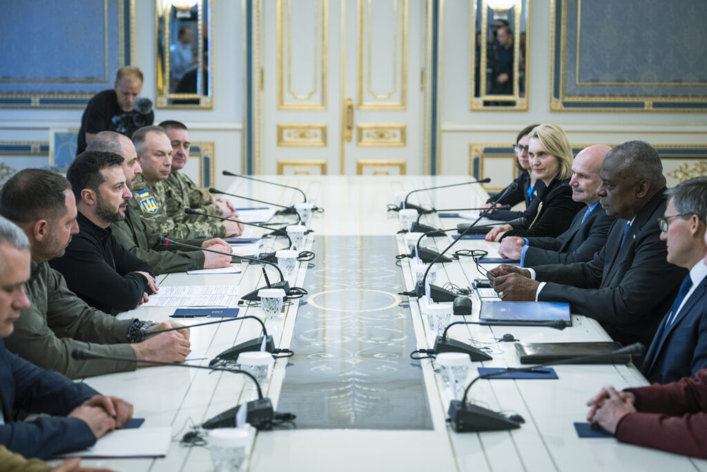 government officials sitting across from each other at a long table