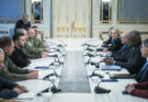 government officials sitting across from each other at a long table