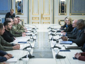 government officials sitting across from each other at a long table