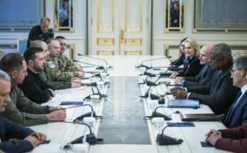 government officials sitting across from each other at a long table