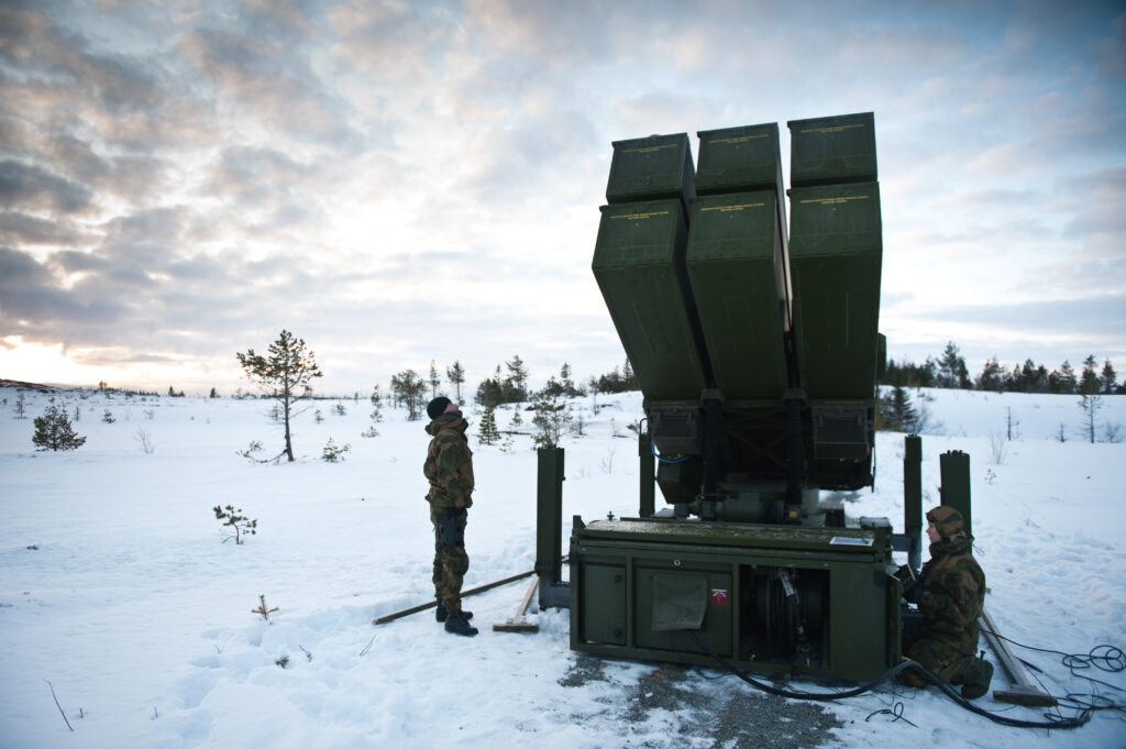 soldiers inspect a missile launcher in the snow