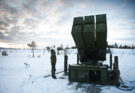 soldiers inspect a missile launcher in the snow