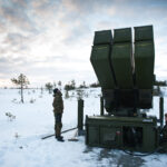 soldiers inspect a missile launcher in the snow