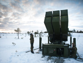 soldiers inspect a missile launcher in the snow