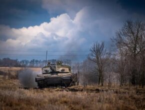 A tank donated by Britain drives through a field in Ukraine