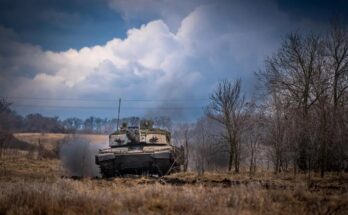 A tank donated by Britain drives through a field in Ukraine