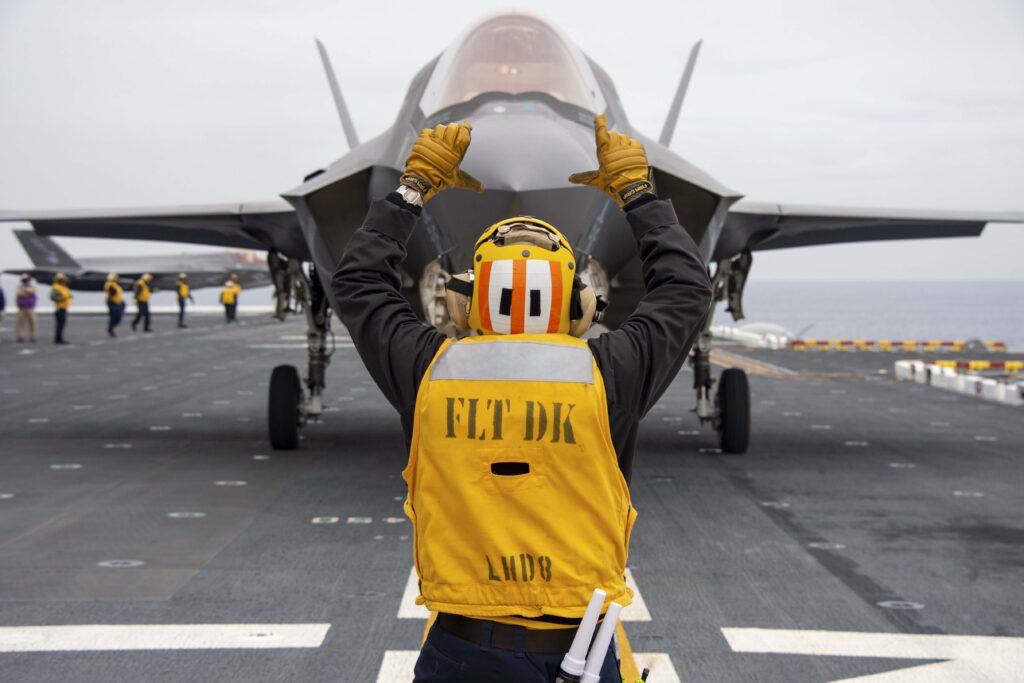 A fighter jet receives instructions on the flight deck