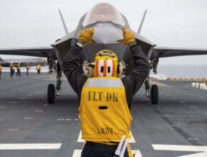 A fighter jet receives instructions on the flight deck