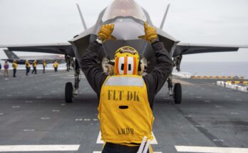 A fighter jet receives instructions on the flight deck