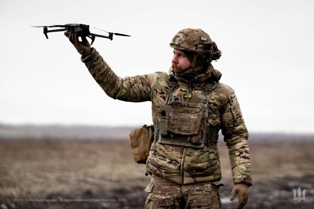 a soldier holds up a small drone 