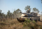 A tank drives through the Australian bush