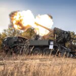 Flames erupt from the barrel of a self-propelled howitzer