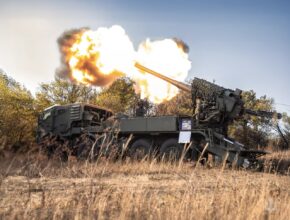 Flames erupt from the barrel of a self-propelled howitzer