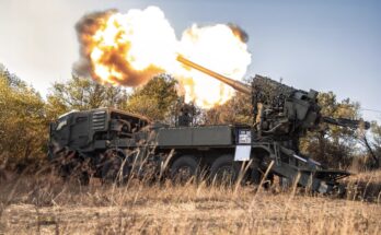 Flames erupt from the barrel of a self-propelled howitzer
