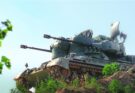 An air defense system sits on a ridge.