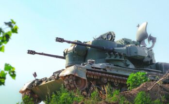An air defense system sits on a ridge.