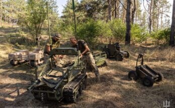 Soldiers work with unmanned ground vehicles in a forest