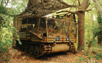 An armored vehicle hides in a forest.