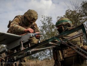 soldiers work on a drone