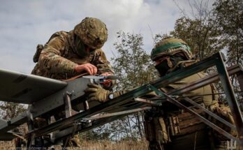 soldiers work on a drone