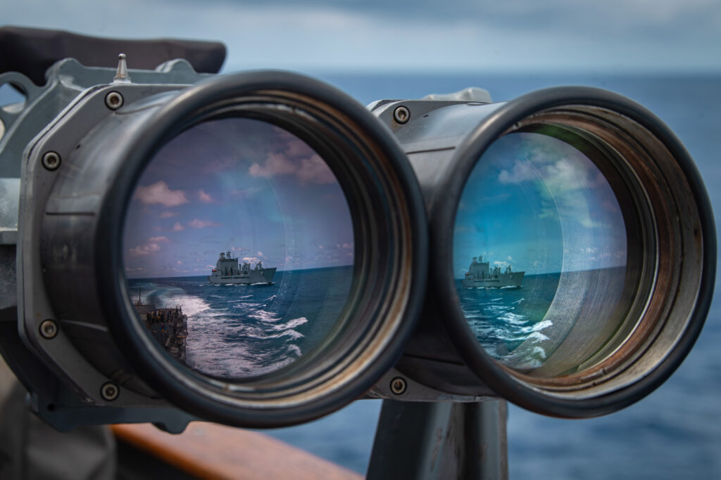 Reflection of a ship on a pair of mounted binoculars.
