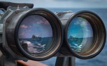 Reflection of a ship on a pair of mounted binoculars.