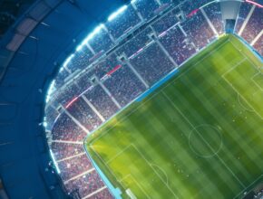 Aerial drone view of modern football soccer pitch sports stadium ground at night lights